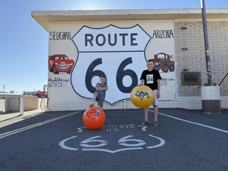 Dwójka dzieci stoi na znaku Route 66 
